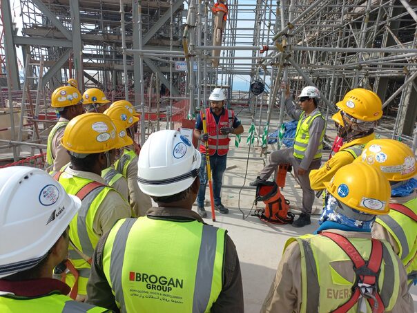 workers with hardhats on a building site surrounded by scaffolding