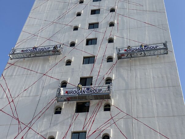multiple suspended access cradles on the side of a buildings in uae